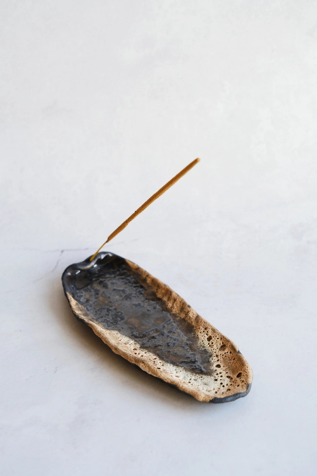 Volcanic Echo incense tray by Laima Ceramics on dark background