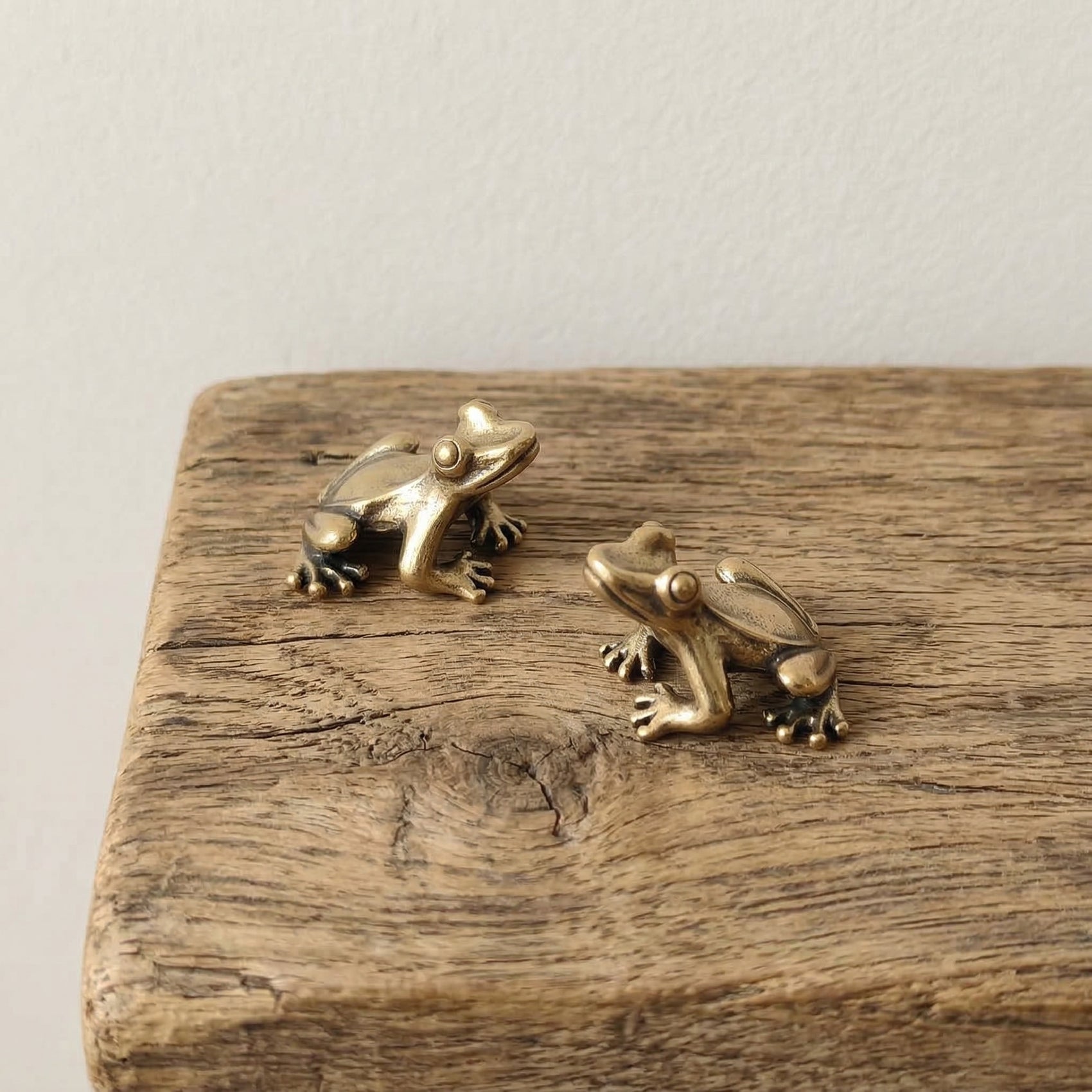 he Harmonic Herald miniature solid brass frog pair on natural wood block showing aged patina detail