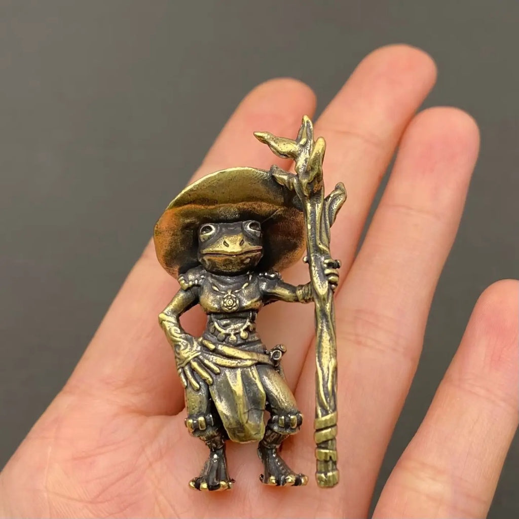 Close-up of The Quiet Alchemist brass wizard frog showing hand-cast surface detail and wizard hat