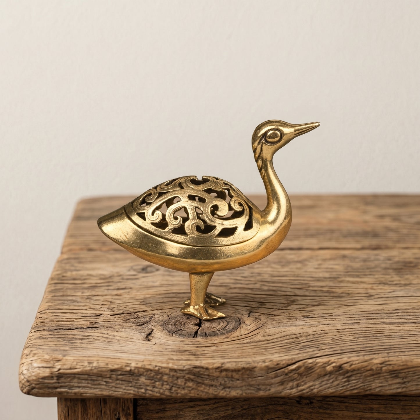 The Wild Goose brass incense burner held in a hand to show its size, about 3.5 inches long