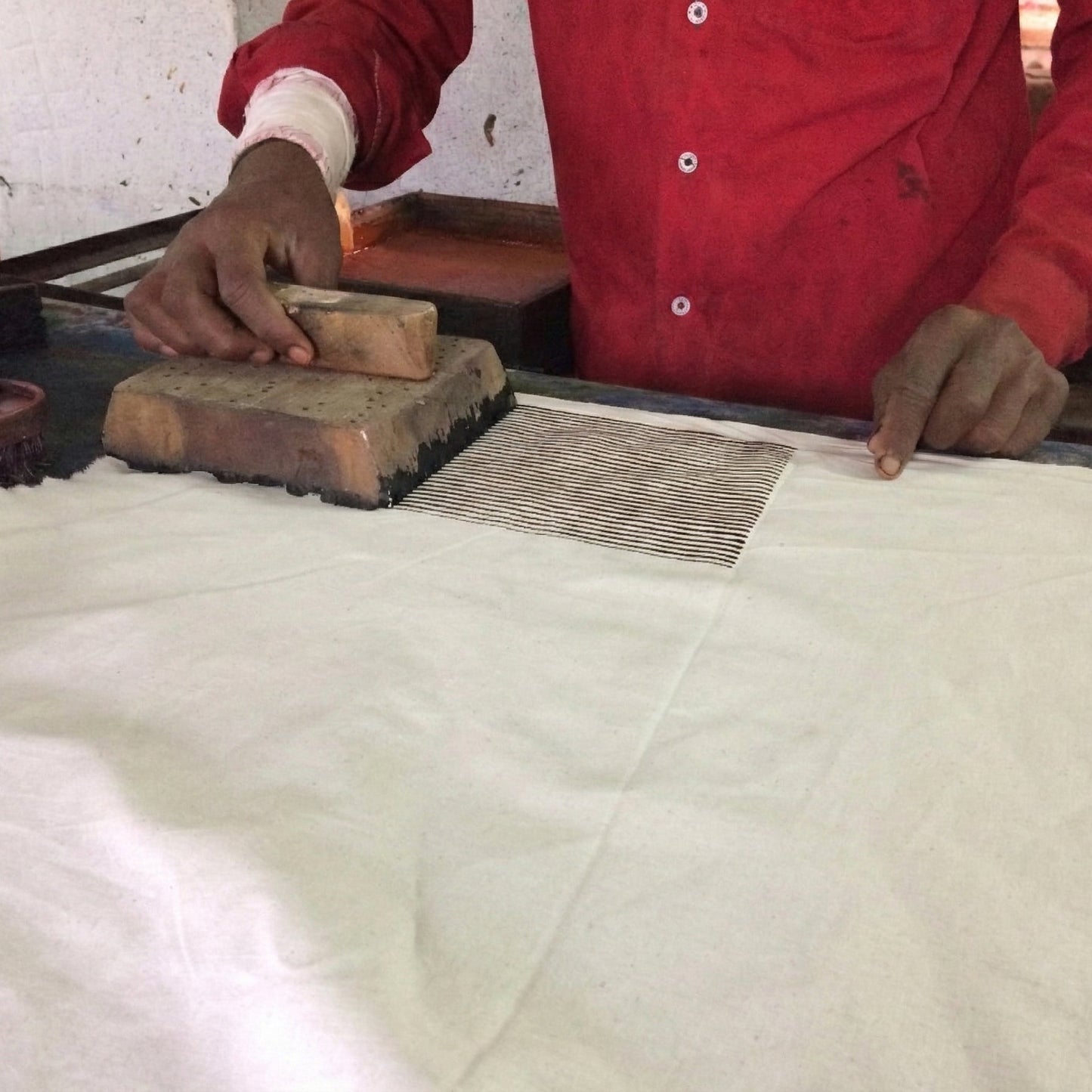 Person using a traditional printing block on fabric