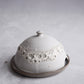 Ceramic butter dish with textured surface on a light gray background