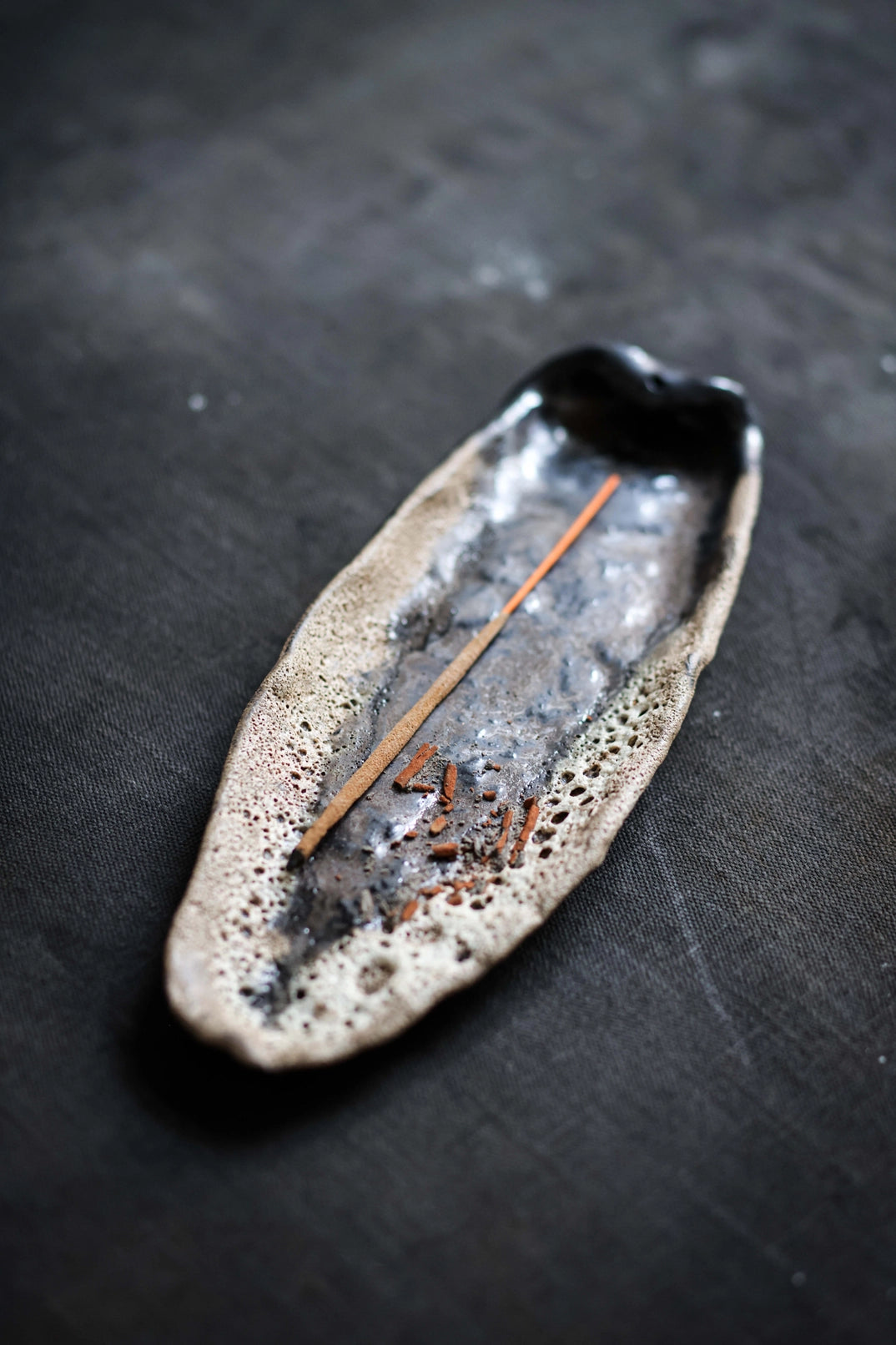 Latvian handcrafted incense dish with organic texture and incense stick