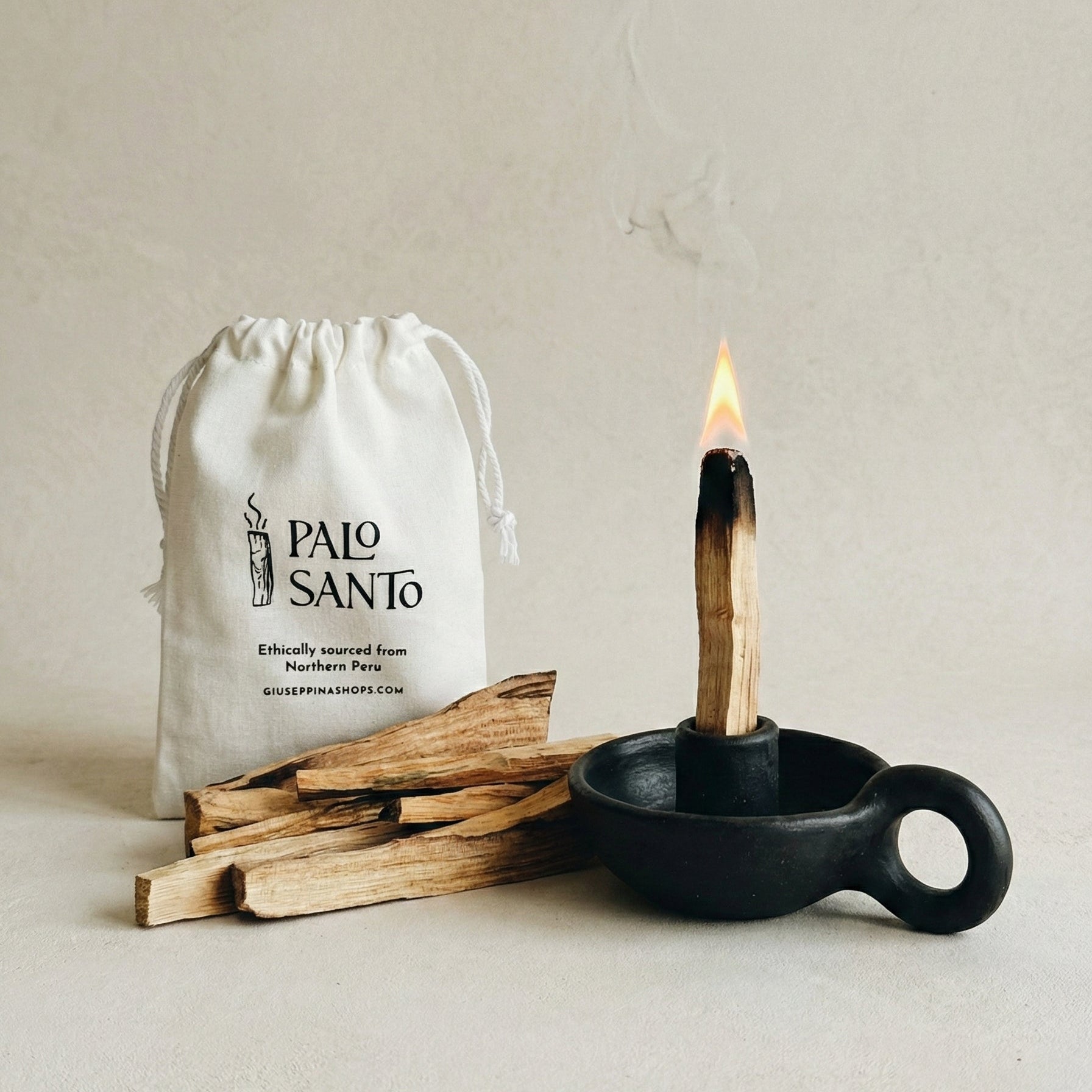 Palo Santo sticks, a lighter, and a drawstring bag labeled 'Palo Santo' on a neutral background.