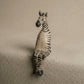 Zebra figurine on a textured surface with a neutral background