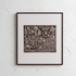 Framed artwork with a detailed design on a textured white wall