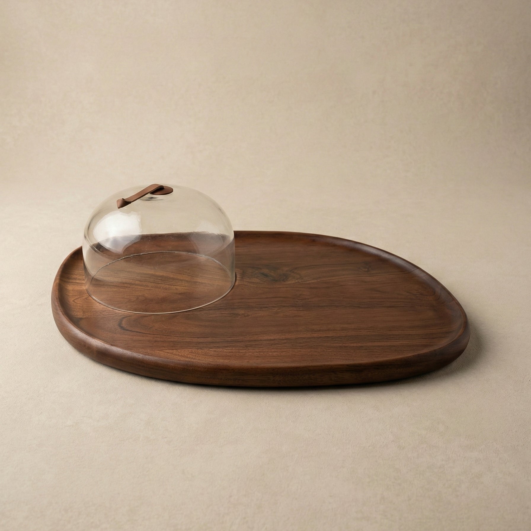 The Acacia Provision Board close-up showing acacia wood grain detail alongside the glass cloche dome and sculpted handle