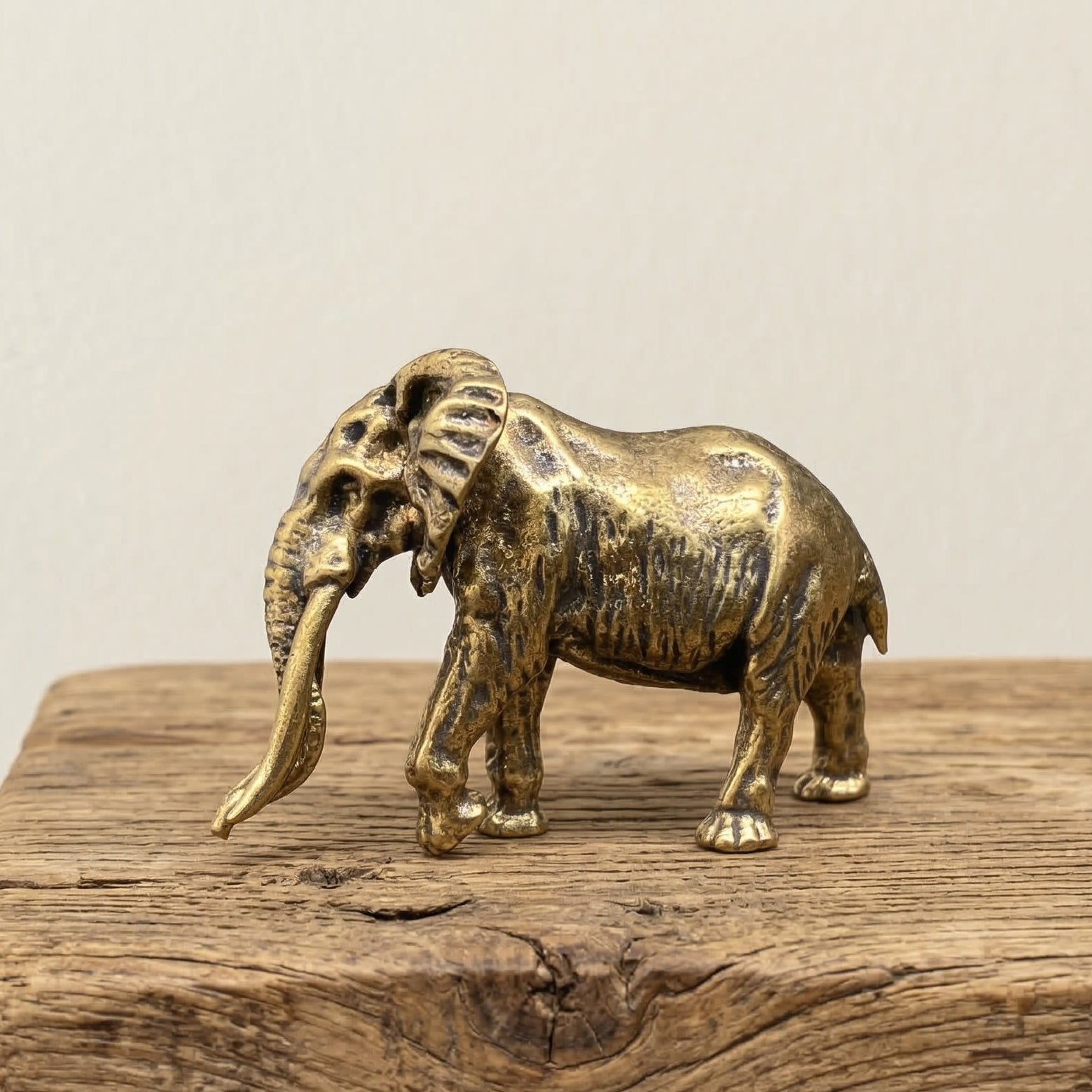 The Ancient Sage miniature brass woolly mammoth with raised trunk and tusks, showing textured fur detail and warm aged patina, from the WILLAGE Tiny Objects collection