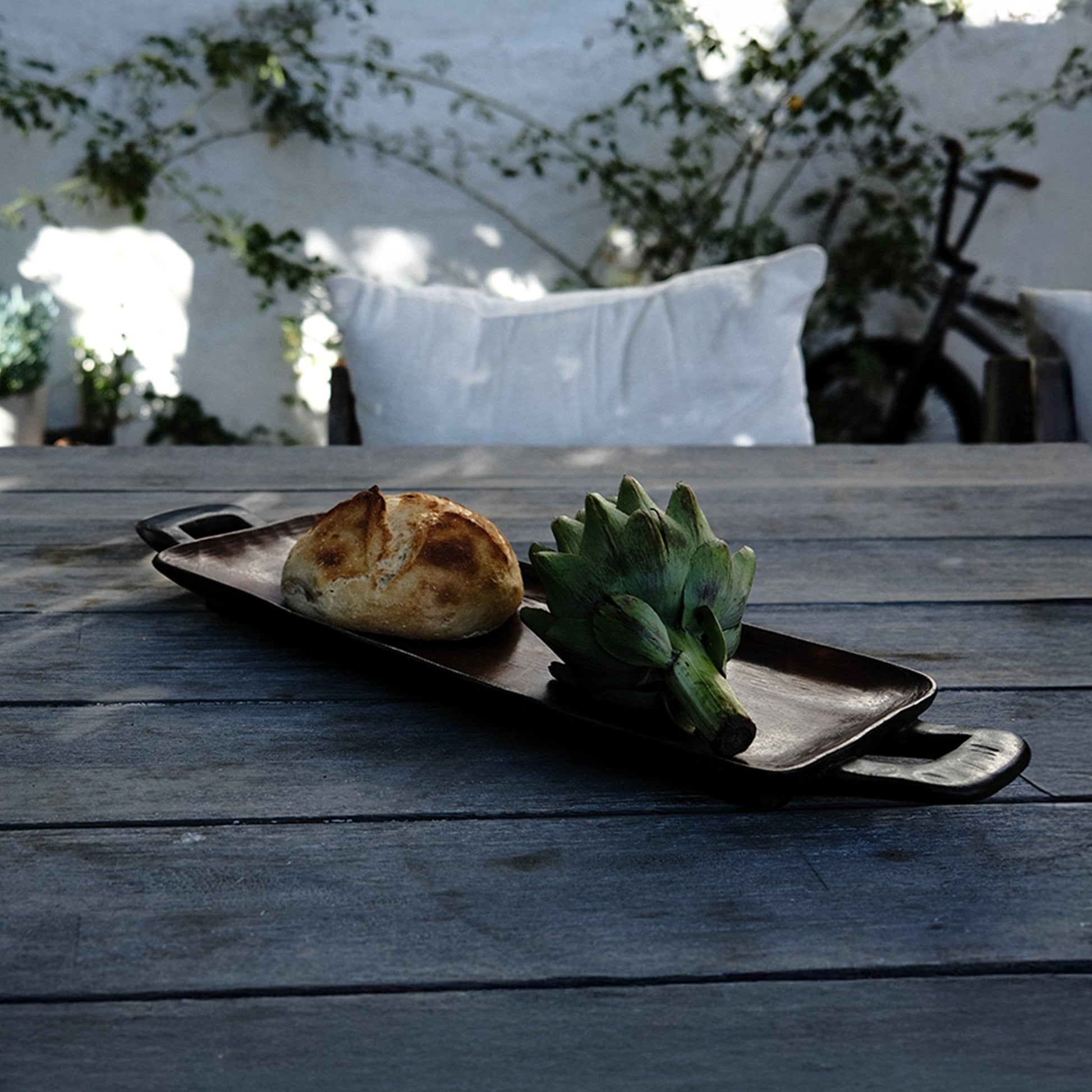 Hand-carved African hardwood serving tray styled on a table with food, from Togu'na South Africa
