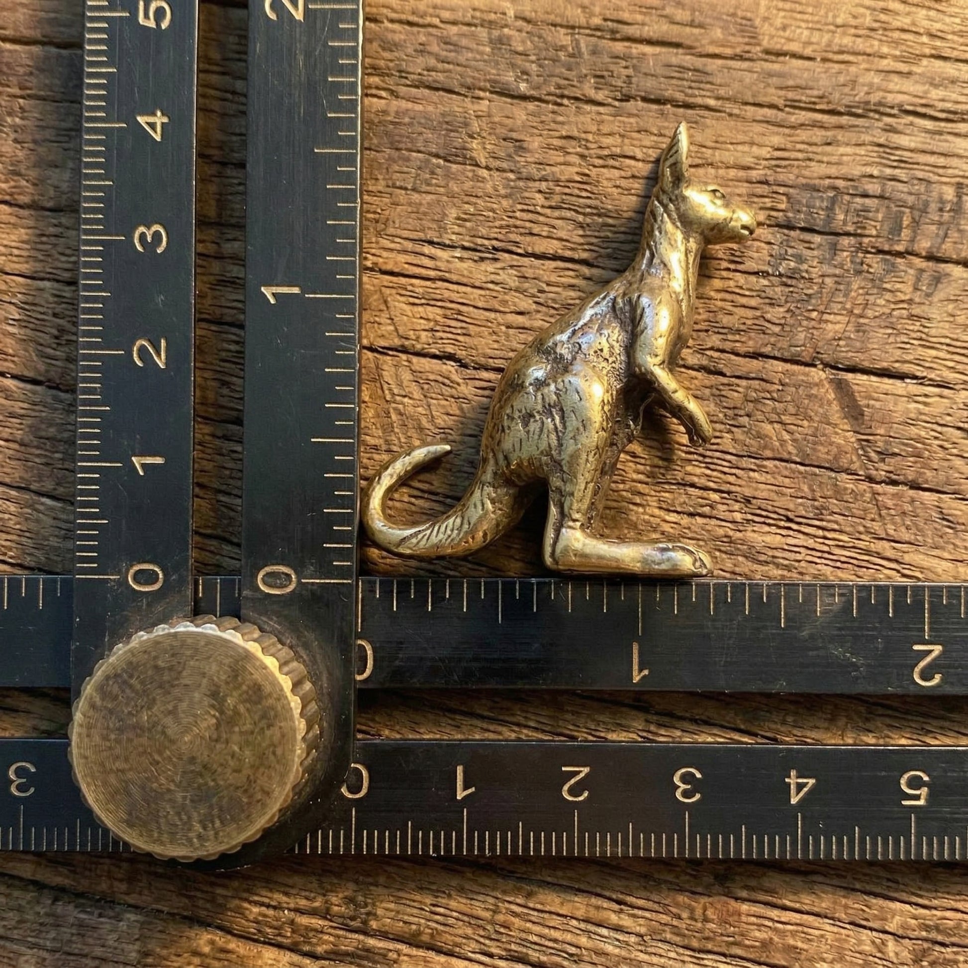 The Boundless Adventurer miniature brass kangaroo held in hand to show scale, with detailed ears and tail