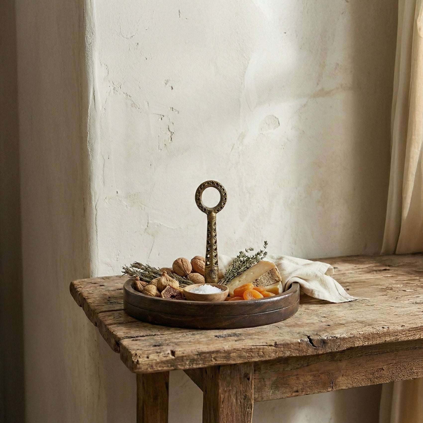 The Brass Hold wood serving board with Dhokra brass handle displayed on a table surface, handcrafted in India, from WILLAGE
