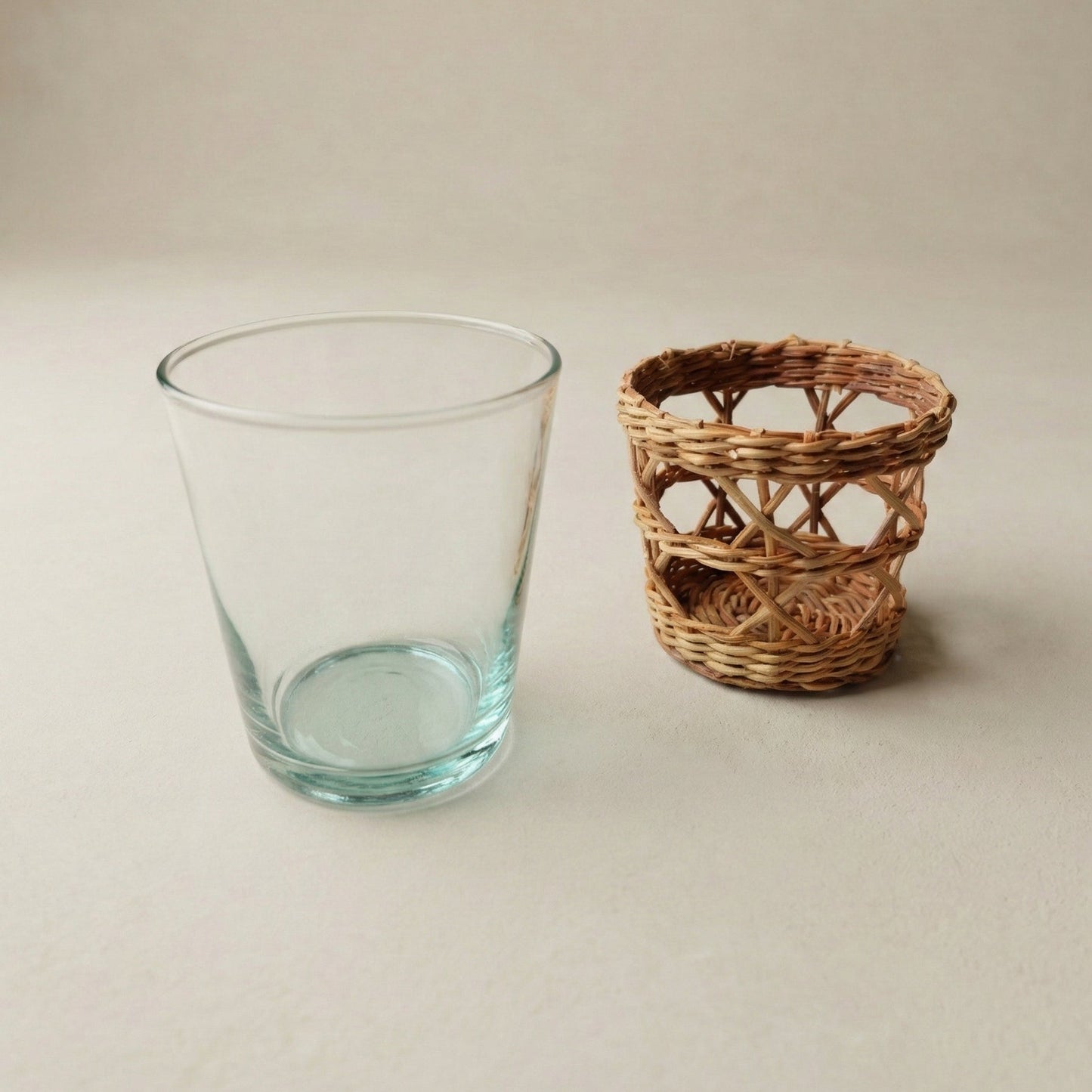 The Cỏ Tumbler close-up showing hand-woven seagrass sleeve texture and clear recycled glass underneath