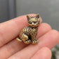 Close-up of The Curious One brass kitten showing hand-cast detail and small scale