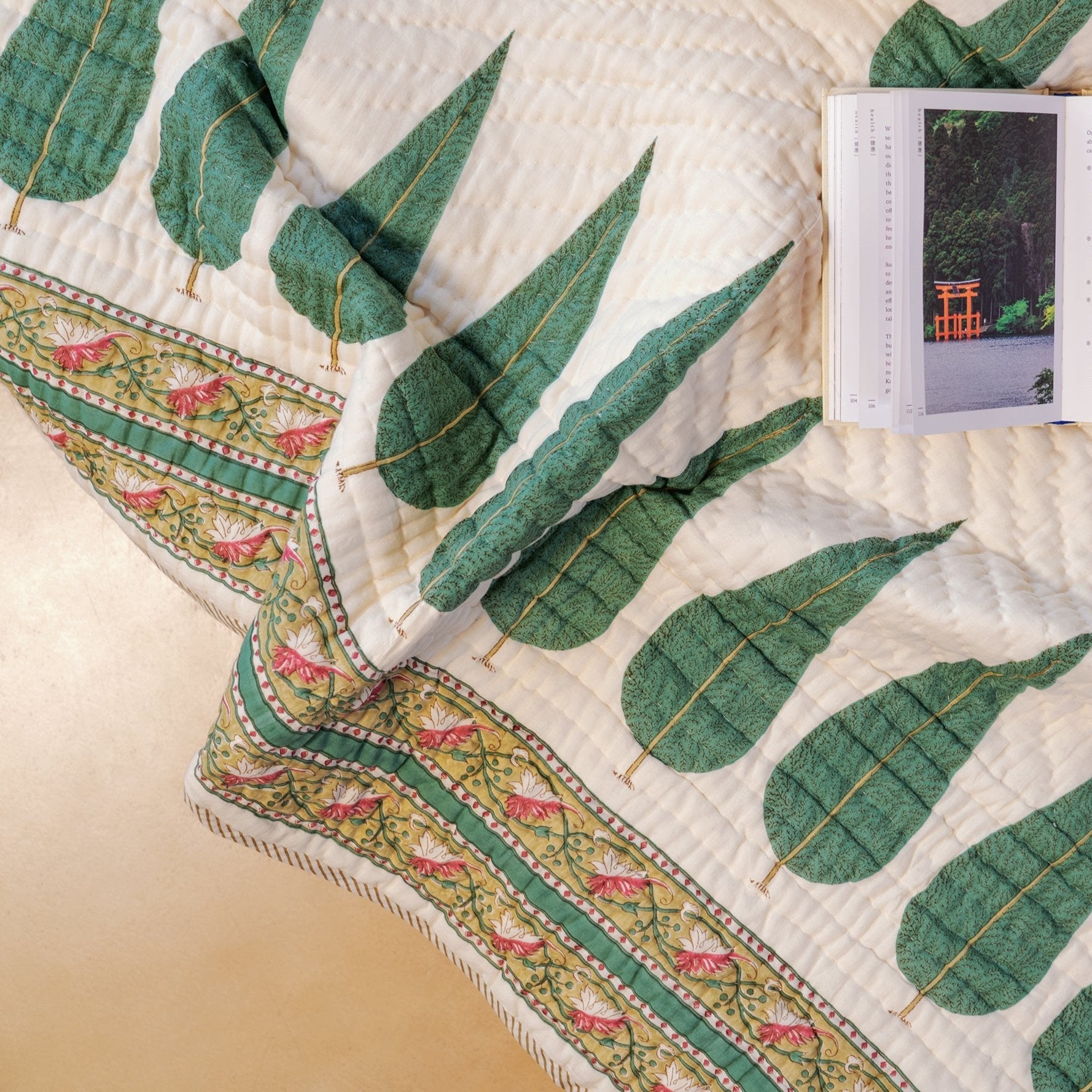 Close-up of cypress leaf block-print pattern and border on hand-stitched cotton quilt, handcrafted in Jaipur India