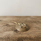 The Eternal Voyager miniature brass horseshoe crab held in hand to show scale, with detailed shell texture and golden patina