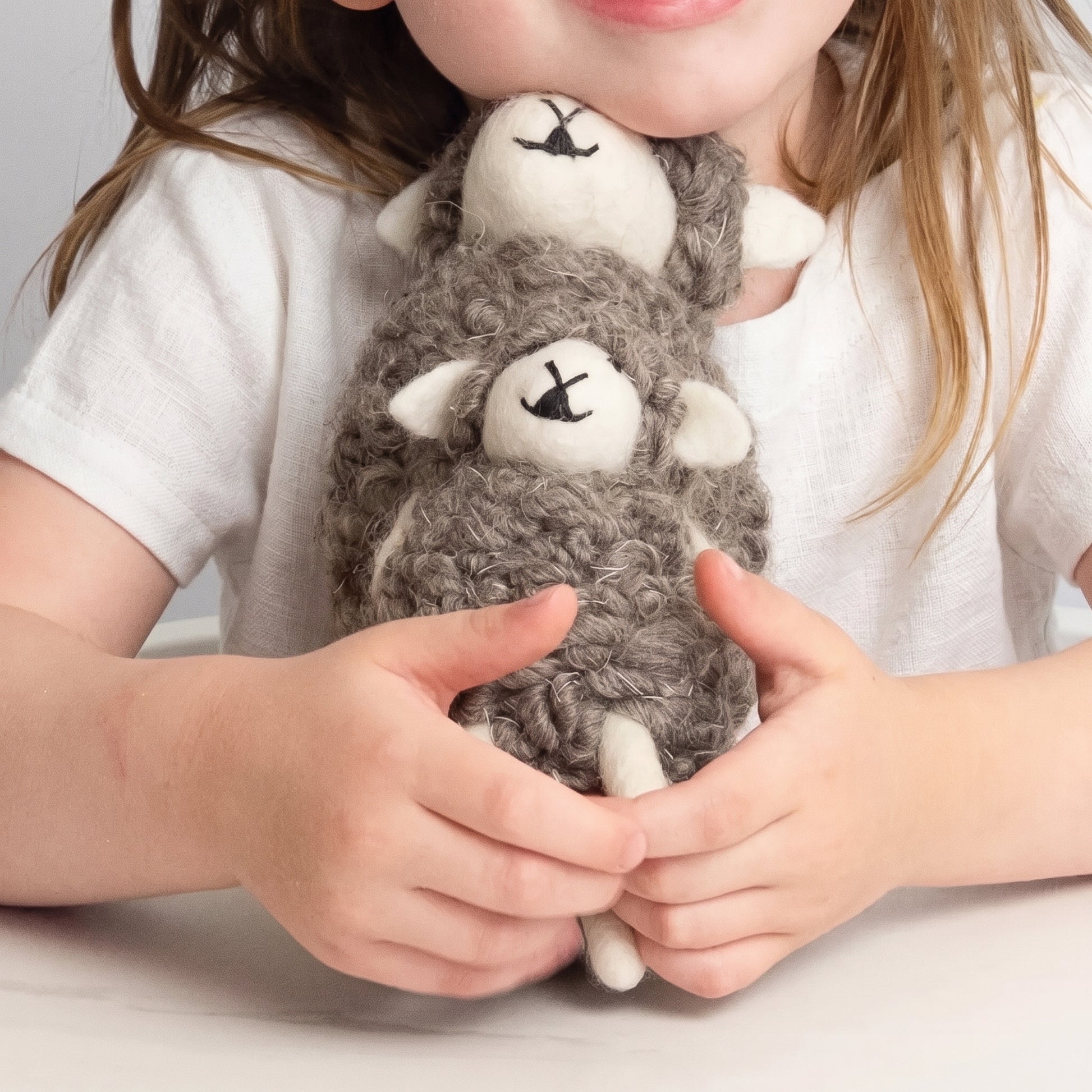 Two wooly hand-felted sheep in natural grey wool with cream faces and legs