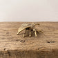 Brass bee figurine held in an open palm to show its palm-sized scale, veined wings, and textured thorax
