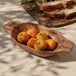 The Gambare Bowl hand-carved from Garo Hills wood holding oranges, displayed alongside fresh bread on a linen-covered table in dappled sunlight, handcrafted by Sembertush A. in Meghalaya India, from WILLAGE