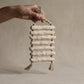 The Gathered Earth Wall Hanging with seven horizontal clay rungs showing raw unglazed texture and mineral variations, hand-built by Conrad and Dina in Canada, from WILLAGE