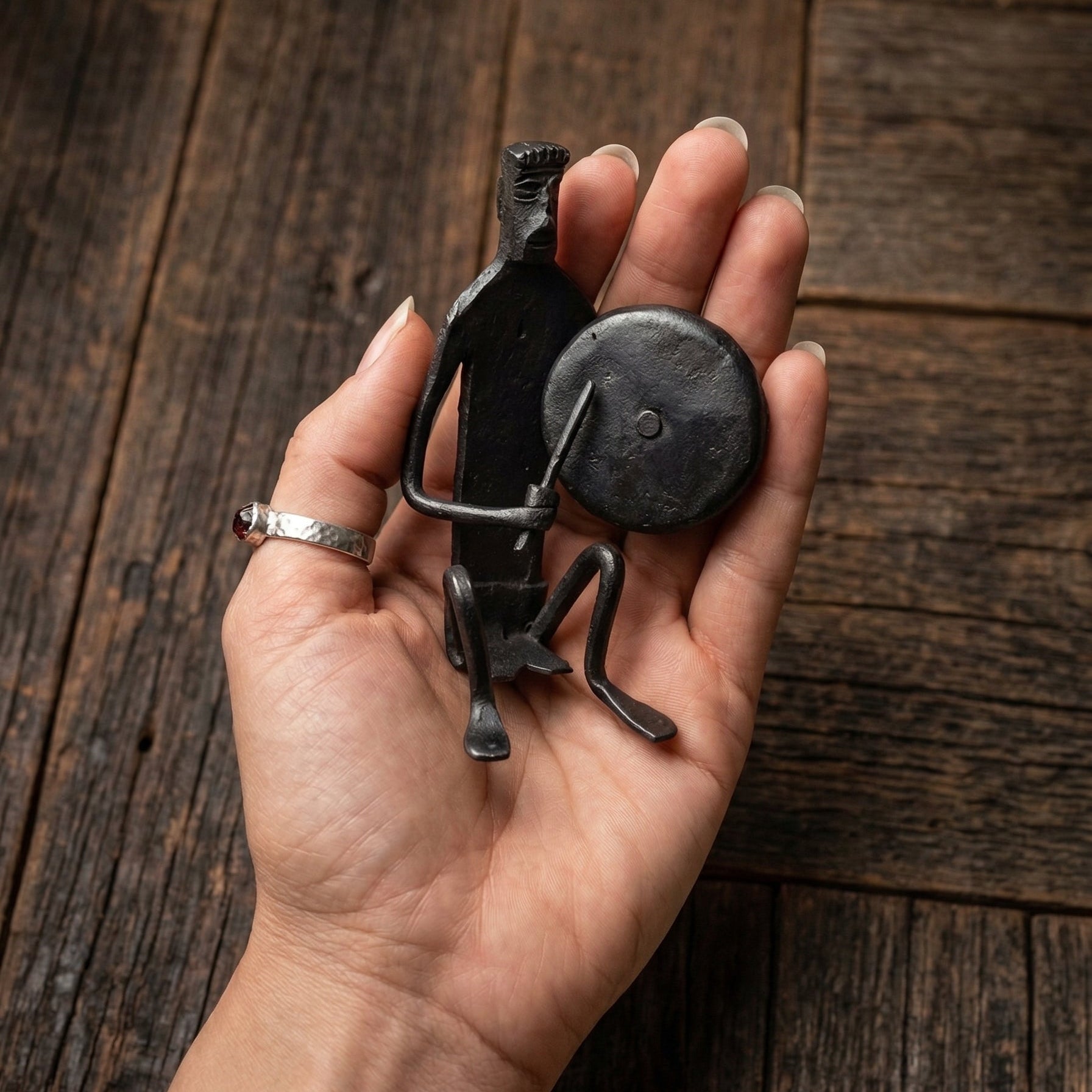 The Gong Players Bastar wrought iron sculpture held in hand to show scale and forged detail
