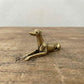 The Graceful Sentinel miniature brass greyhound held in hand to show scale, with sleek silhouette and golden patina