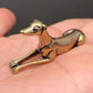 The Graceful Sentinel miniature brass greyhound in a reclining pose with elegant proportions and warm aged patina on a wooden surface, from the WILLAGE Tiny Objects collection