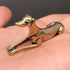 The Graceful Sentinel miniature brass greyhound in a reclining pose with elegant proportions and warm aged patina on a wooden surface, from the WILLAGE Tiny Objects collection