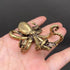  Brass octopus figurine held in an open hand to show its palm-sized scale, tentacles curling around a small brass boat