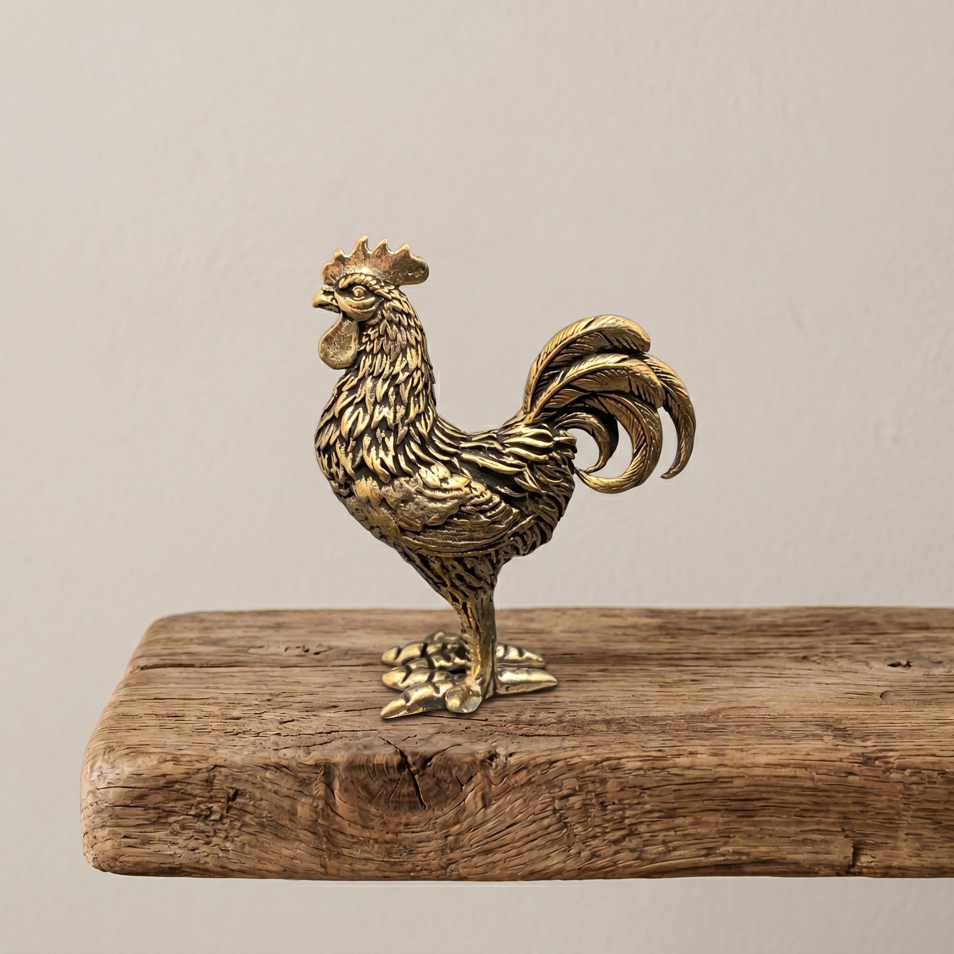 Side view of The Herald brass rooster showing the detailed hackle, saddle, and sweeping tail feathers