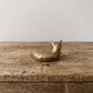  Back view of a lounging brass cat figurine showing striped fur texture and ears, with antique patina