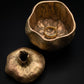 pewter pomegranate box with antique brass finish and hand-worked textured surface, showing the sculpted stem opening