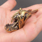 Brass anglerfish figurine resting in an open palm, showing its palm-sized scale, open jaw, and detailed teeth