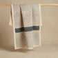The Linear Slate kora cotton kitchen towel showing bold hand block printed horizontal and vertical lines with slate-grey band on natural unbleached cotton, from WILLAGE
