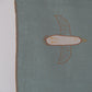 Close-up of handwoven linen baby blanket showing plant-dyed bird motif and natural fiber texture