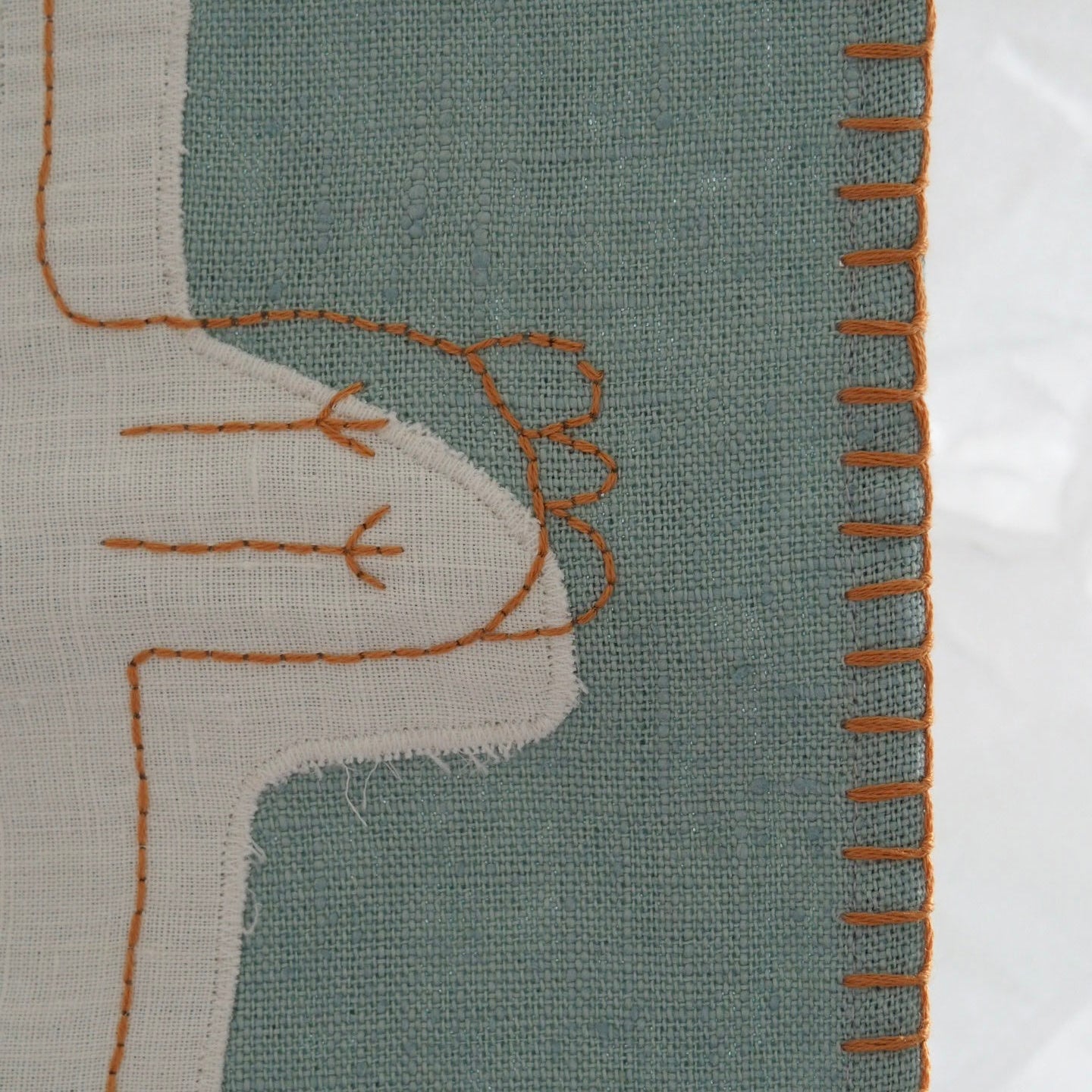 Handwoven edge detail of GOTS-certified organic linen baby blanket, showing stitching and plant-dyed fabric