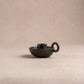 Longpi chamberstick candle holder showing curved finger loop handle and metallic black serpentinite stone finish