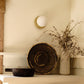 Handwoven Makenge basket mounted as wall art, showing concentric Mbunda weaving pattern, from Zambia