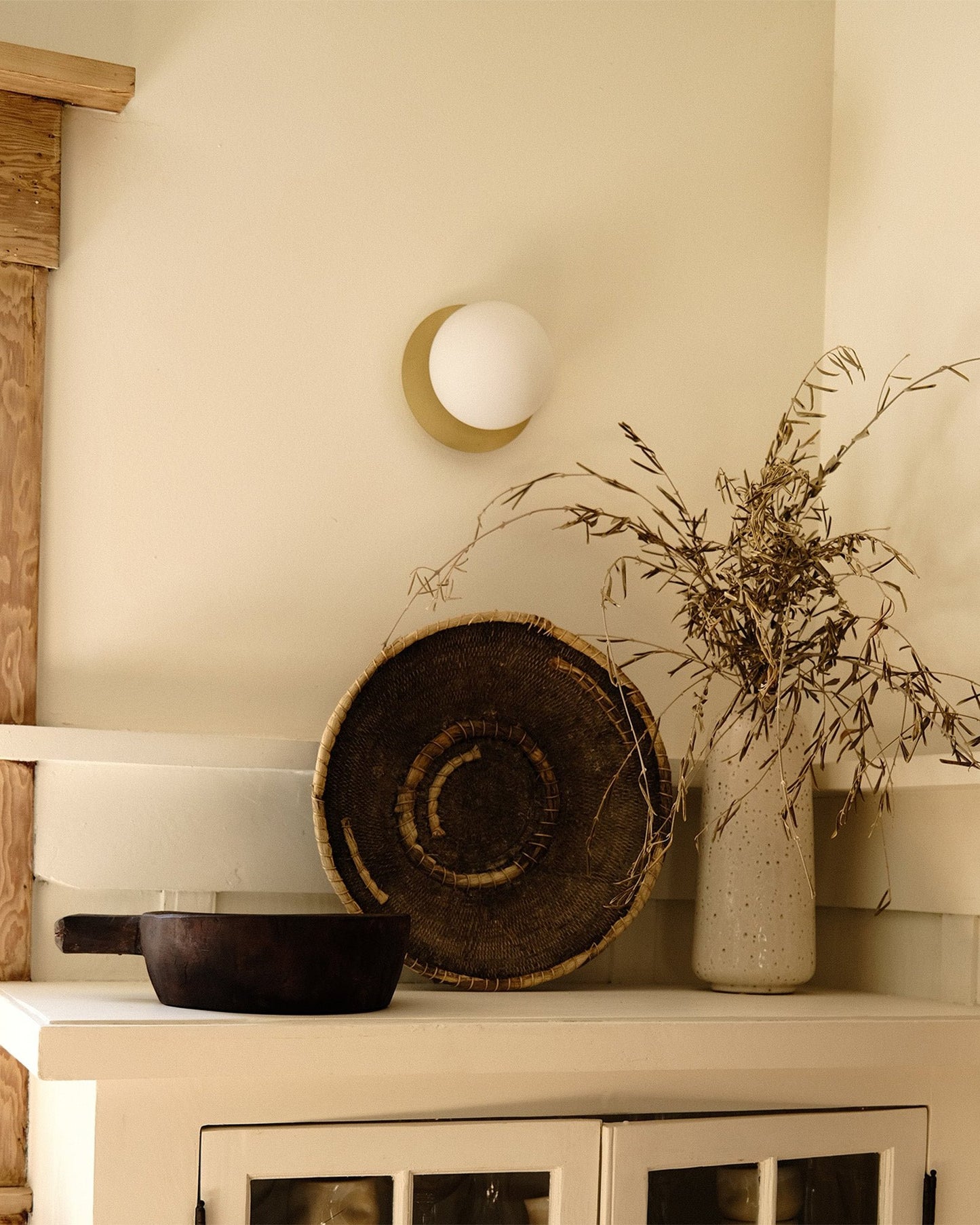Handwoven Makenge basket mounted as wall art, showing concentric Mbunda weaving pattern, from Zambia