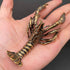 Brass crawfish figurine held in an open hand to show its palm-sized scale and heft
