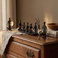 The Music Boat Bastar wrought iron sculpture displayed on an antique wooden dresser with linen runner, craftsmanship books, and companion gong-playing and drummer figures, hand-forged in Chhattisgarh India, from WILLAGE