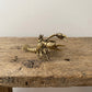 Solid brass lobster figurine with raised claws and fanned tail, antique patina finish, photographed on a gray background