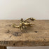 Solid brass lobster figurine with raised claws and fanned tail, antique patina finish, photographed on a gray background