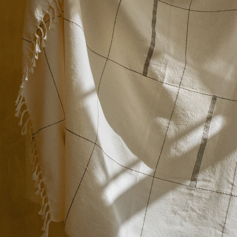 Detail of organic cotton throw showing hand-loomed weave and fringe, handcrafted by Leila Atelier South Africa