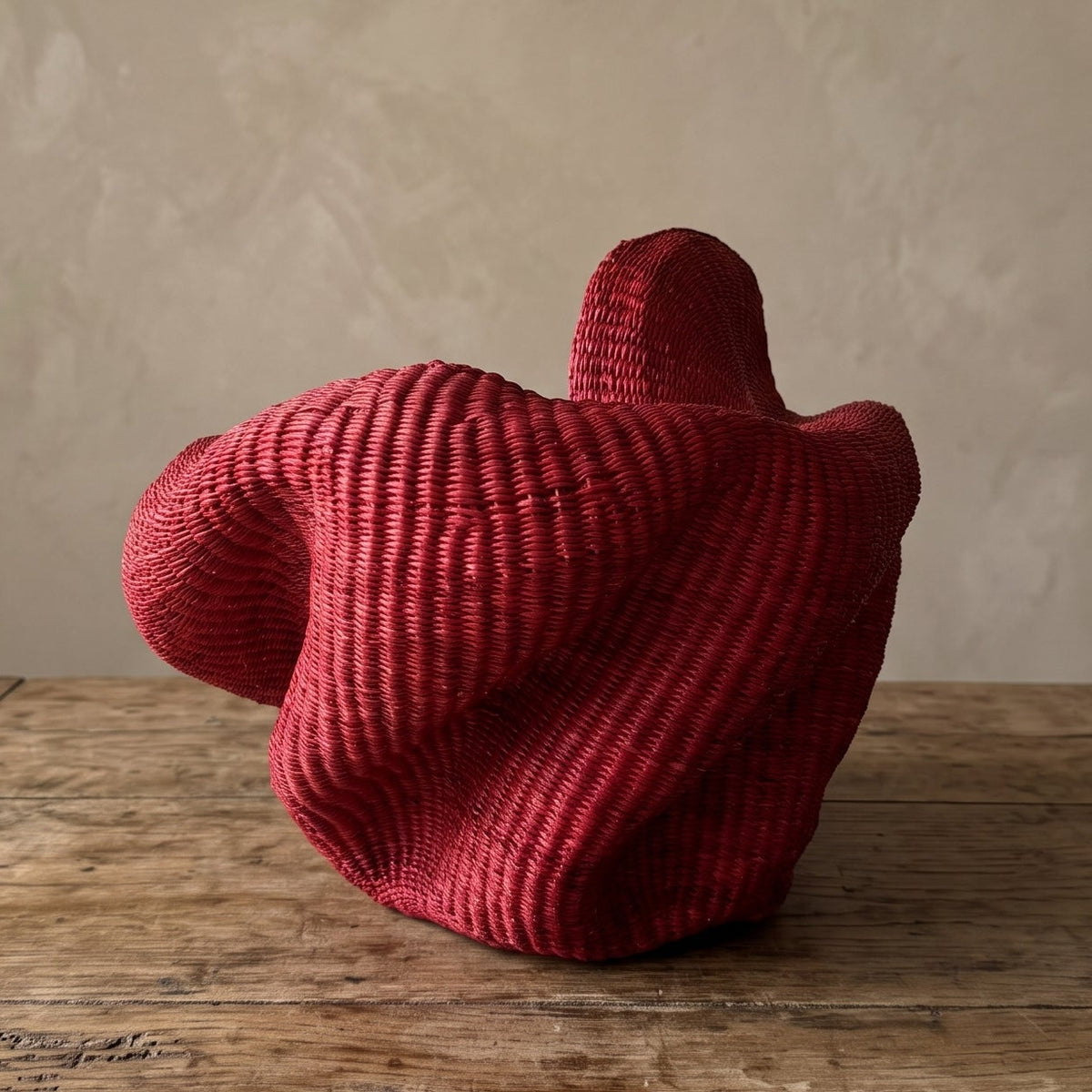 Top-down view into a red woven elephant-grass basket showing the interior weave and sculpted rim
