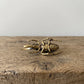Side view of The Powerhouse brass rhinoceros beetle showing the curved horn and detailed legs, antique patina