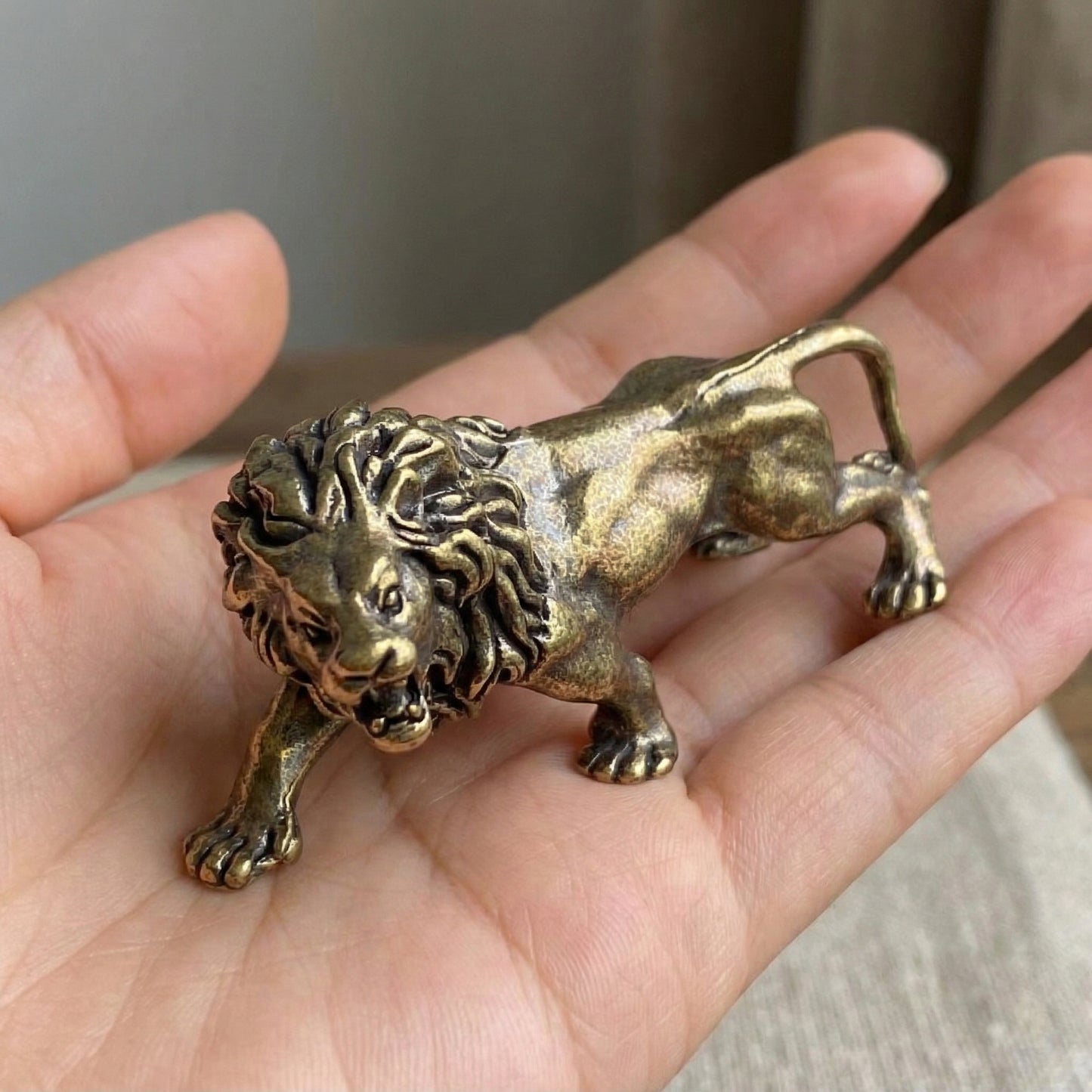 Close-up of The Quiet Sovereign brass lion showing hand-cast mane detail and walking posture