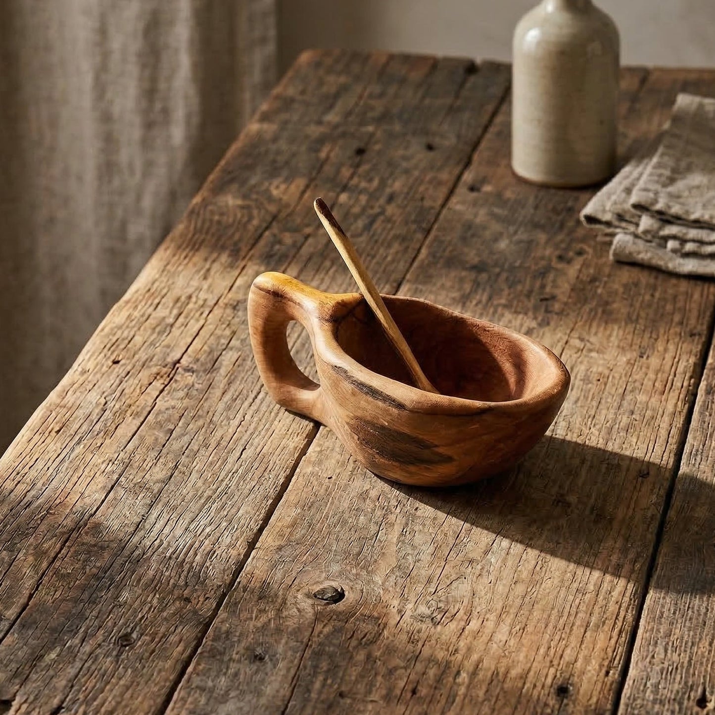 eclaimed olive wood salt pot with hand-tapered wooden spoon on rustic wood table showing natural grain variation