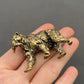 The Resilient Provider miniature brass polar bear with fish in mouth against a neutral background, showing golden patina and fine detail