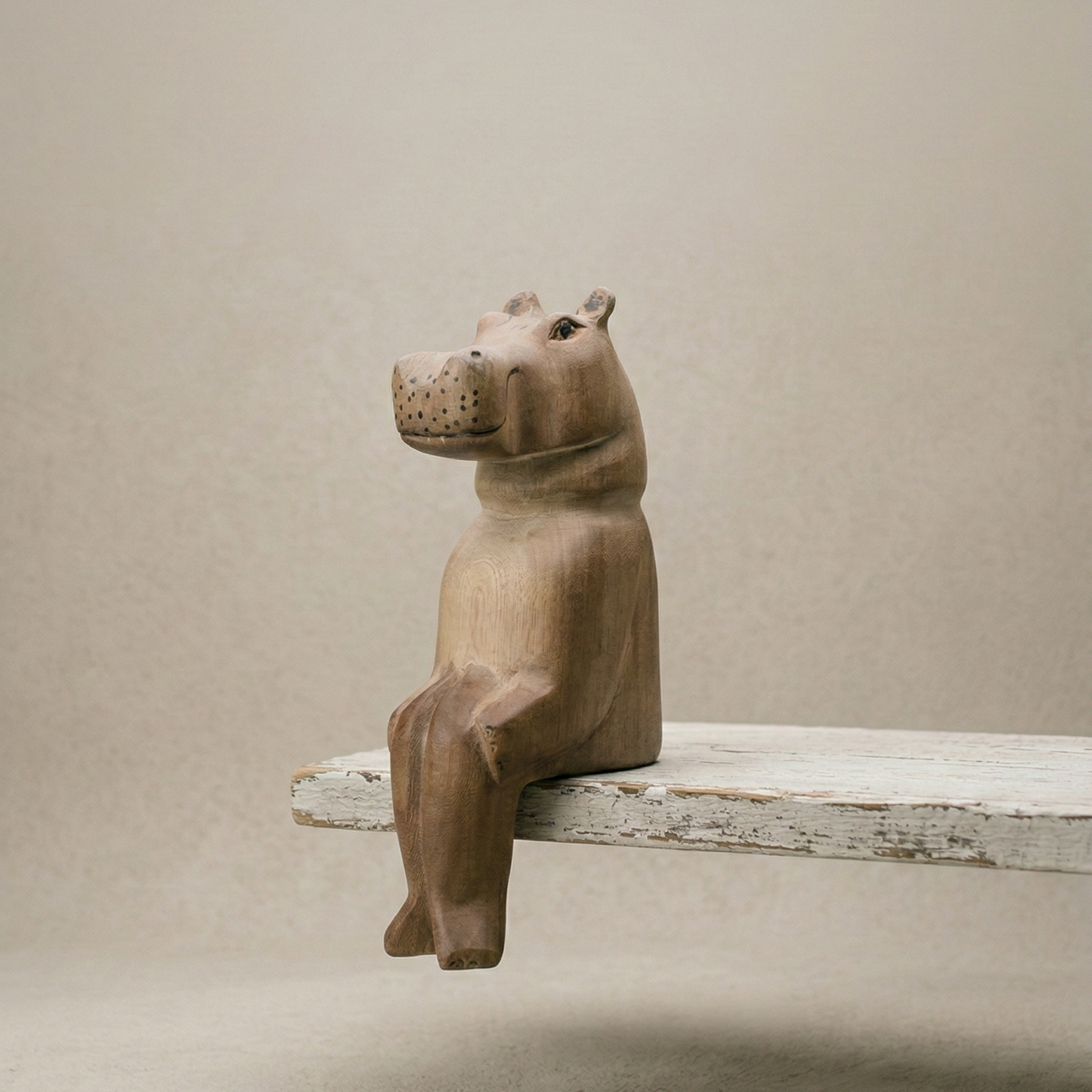 The Resting Hippo hand-carved wooden shelf sitter in a seated pose with dangling legs, carved from jacaranda wood by Kamba tribe artisans in Kenya, from WILLAGE