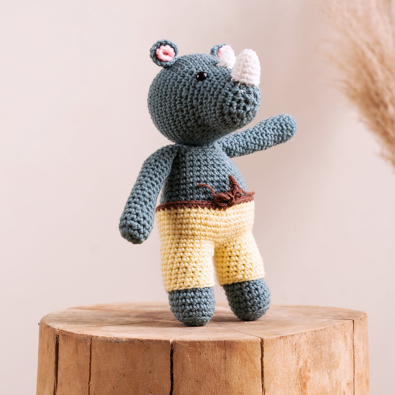 Rocky the Rhino hand-crocheted amigurumi with khaki shorts and leaf accent, handcrafted by The Hobbyt in India, from WILLAGE